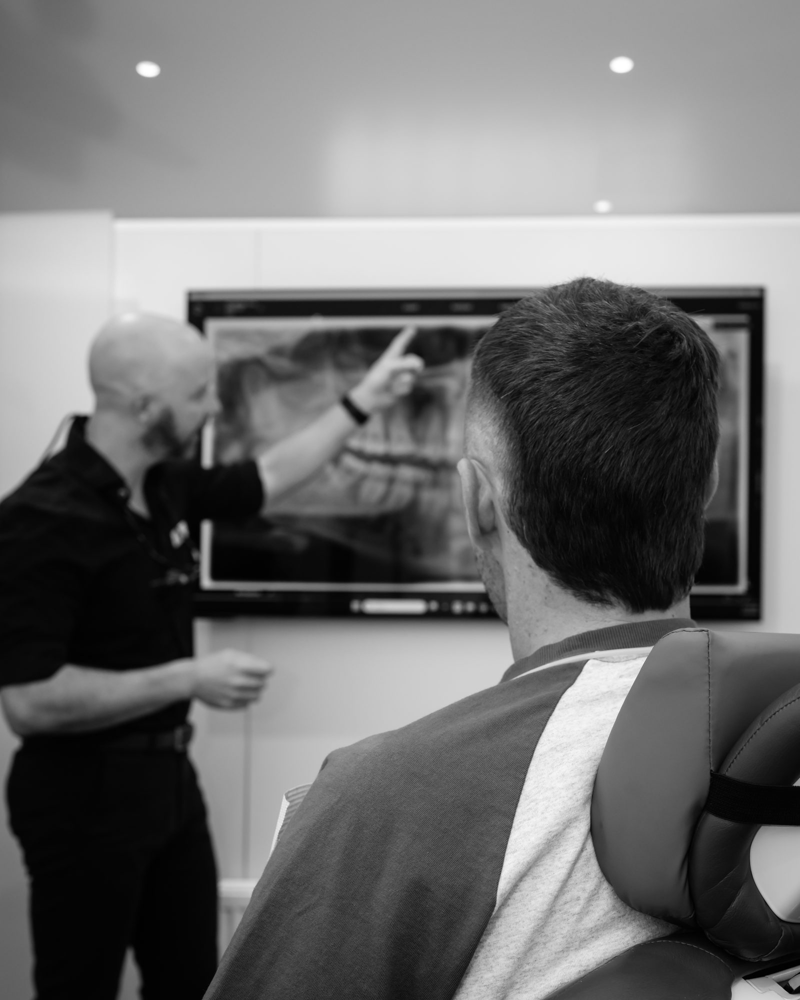 A clinician discussing dental images at Red Hill Dental Practice