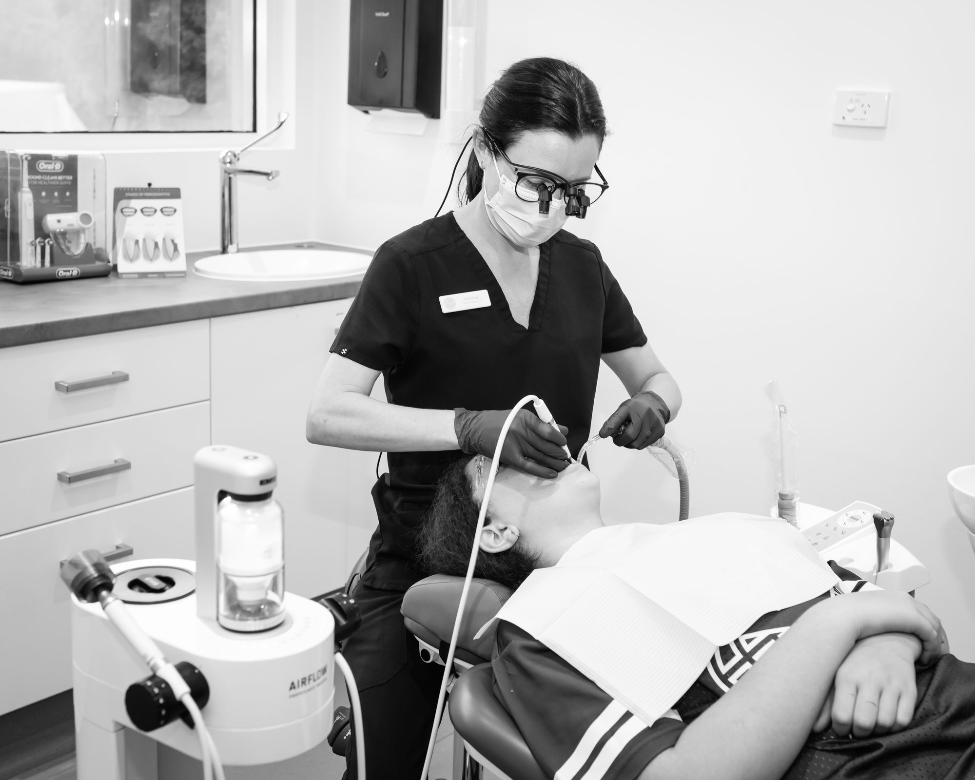 A dental hygienist providing preventive care at Red Hill Dental Practice
